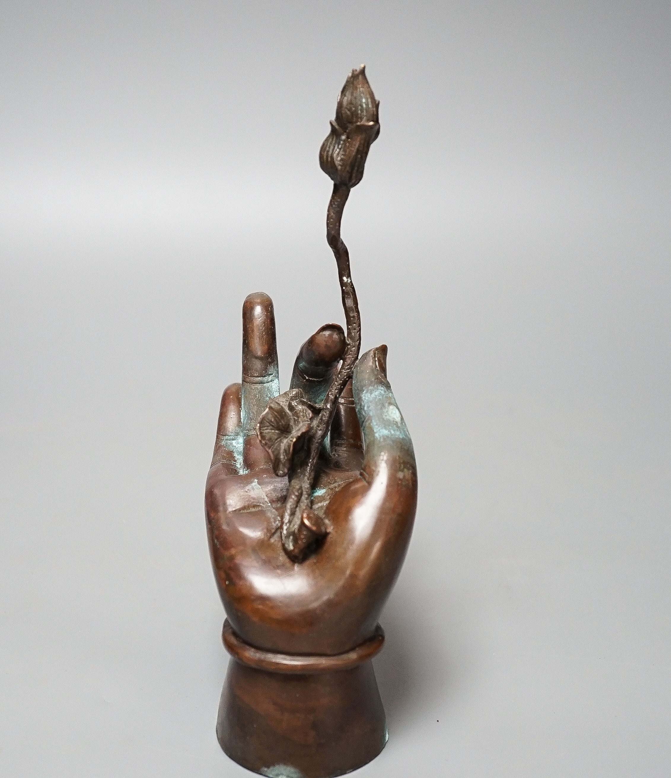 A Himalyan bronze Bodhisattva’s hand, holding a lotus flower 22cm
